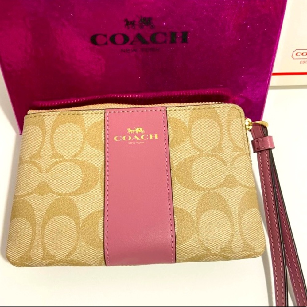 COACH WRISTLET WITH C-SIGNATURE COACH ON IT AND WITH A PINK STRIPE ON FRONT.